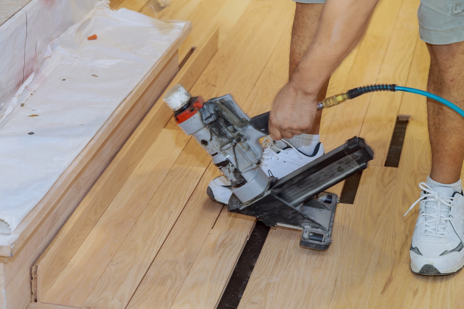 handyman installing wooden floor in new house in u 2026 03 25 00 44 49 utc Large